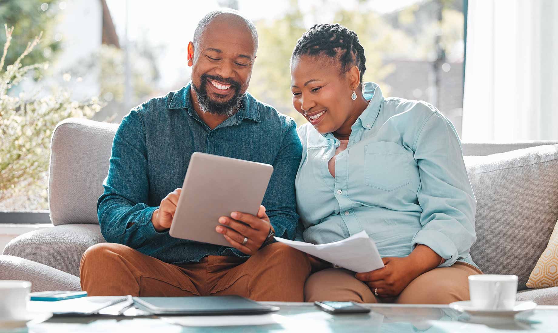 Couple looking at homes on ipad social media ads in living room