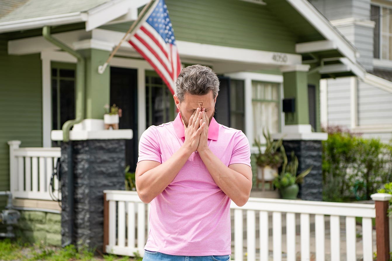 Frustrated man with beard in fron of new home