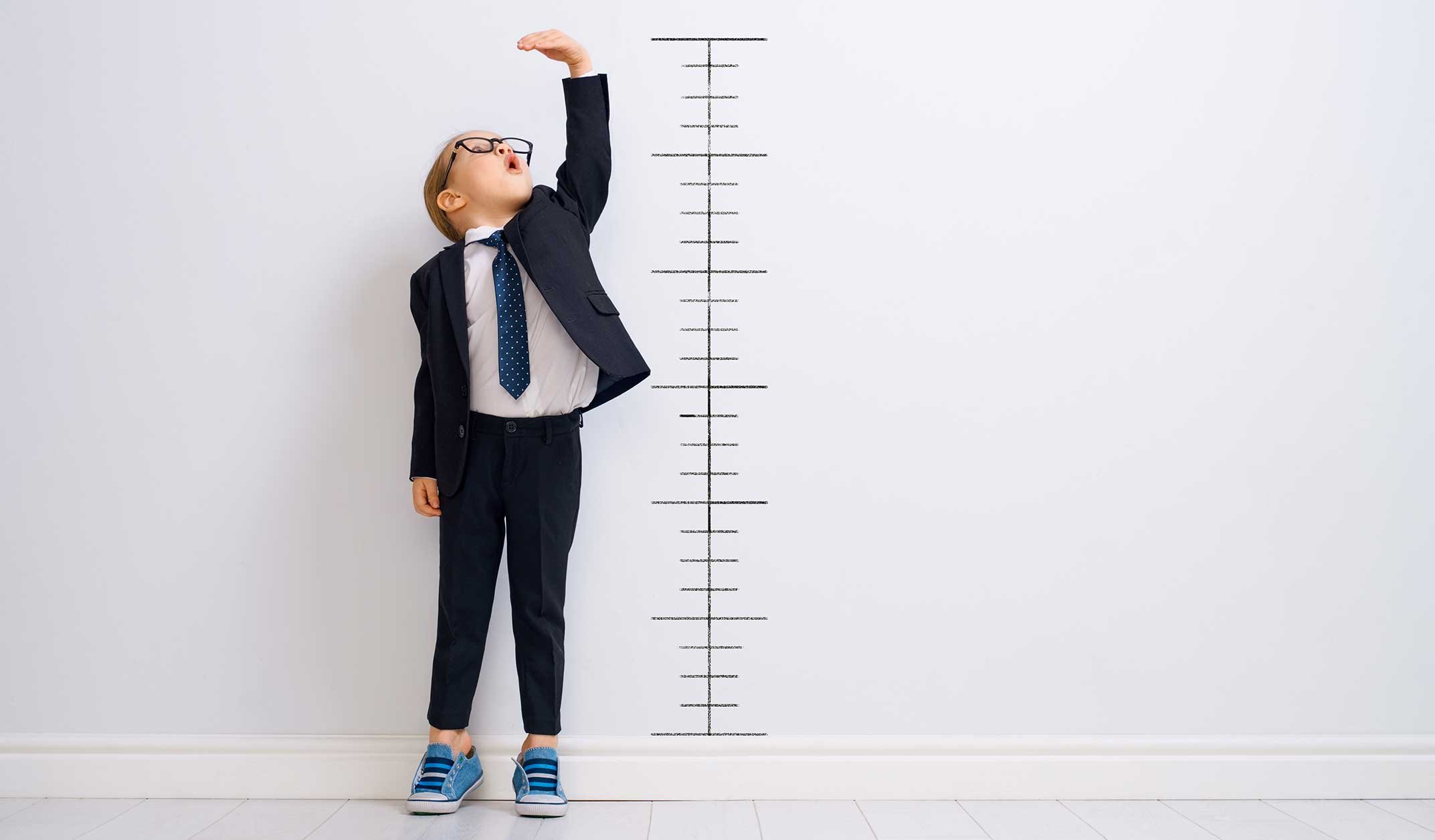 Kid-measuring-success-with-pencil-marks-on-wall
