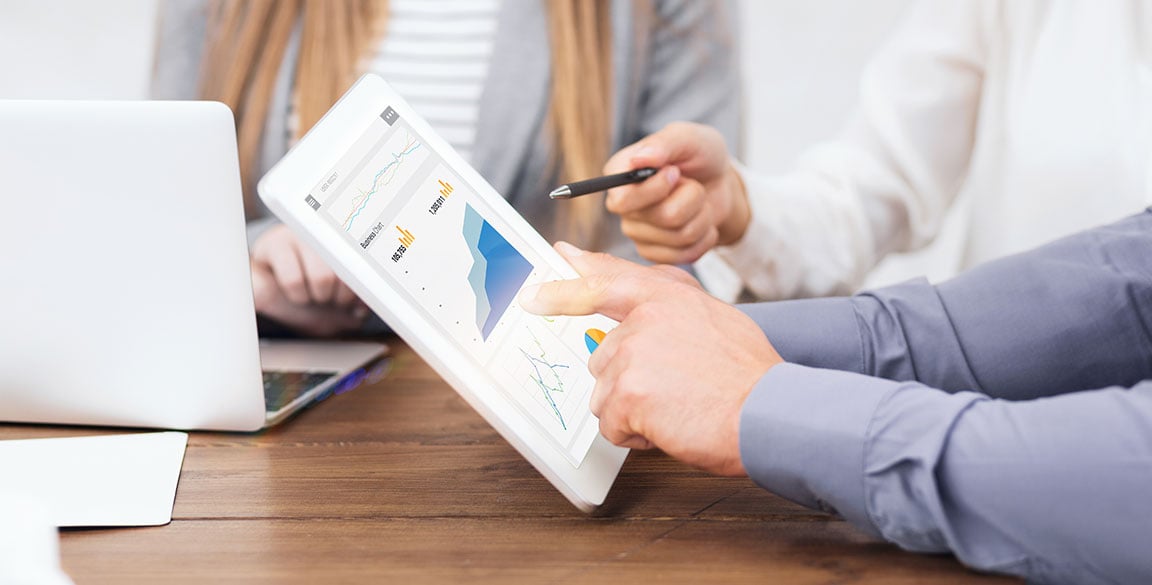 Marketing professionals reviewing increased website traffic stats on ipad