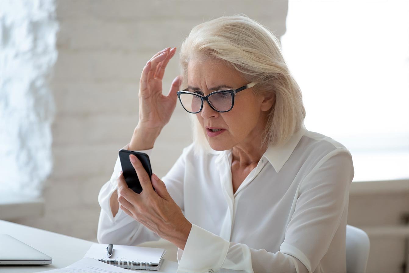 Middle aged woman upset and looking at her phone