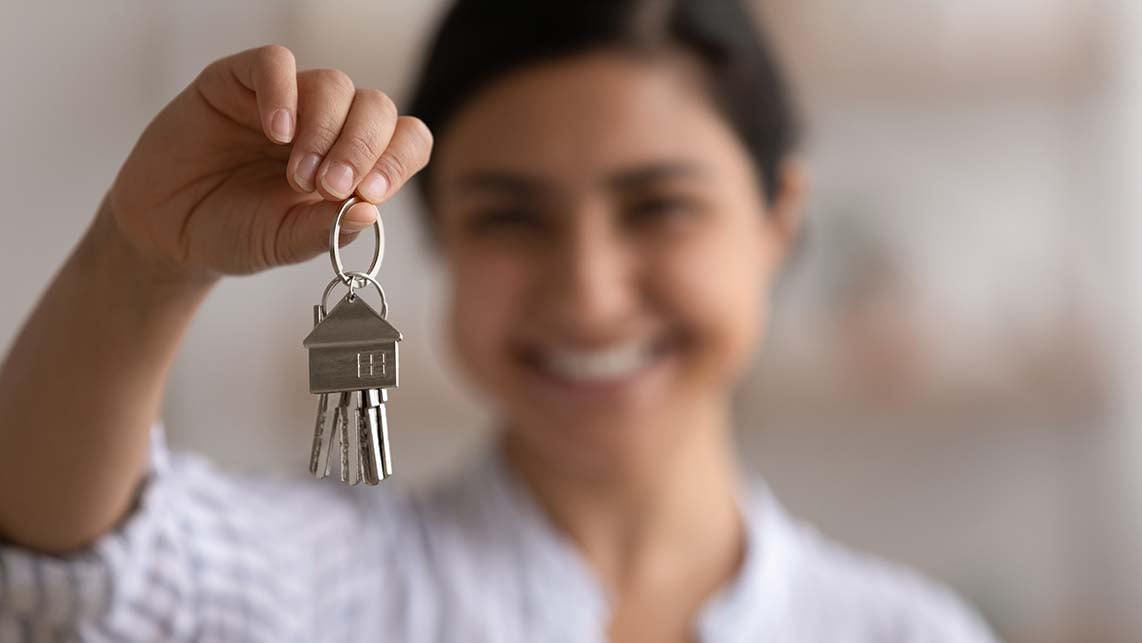 Person holding keys to their new home