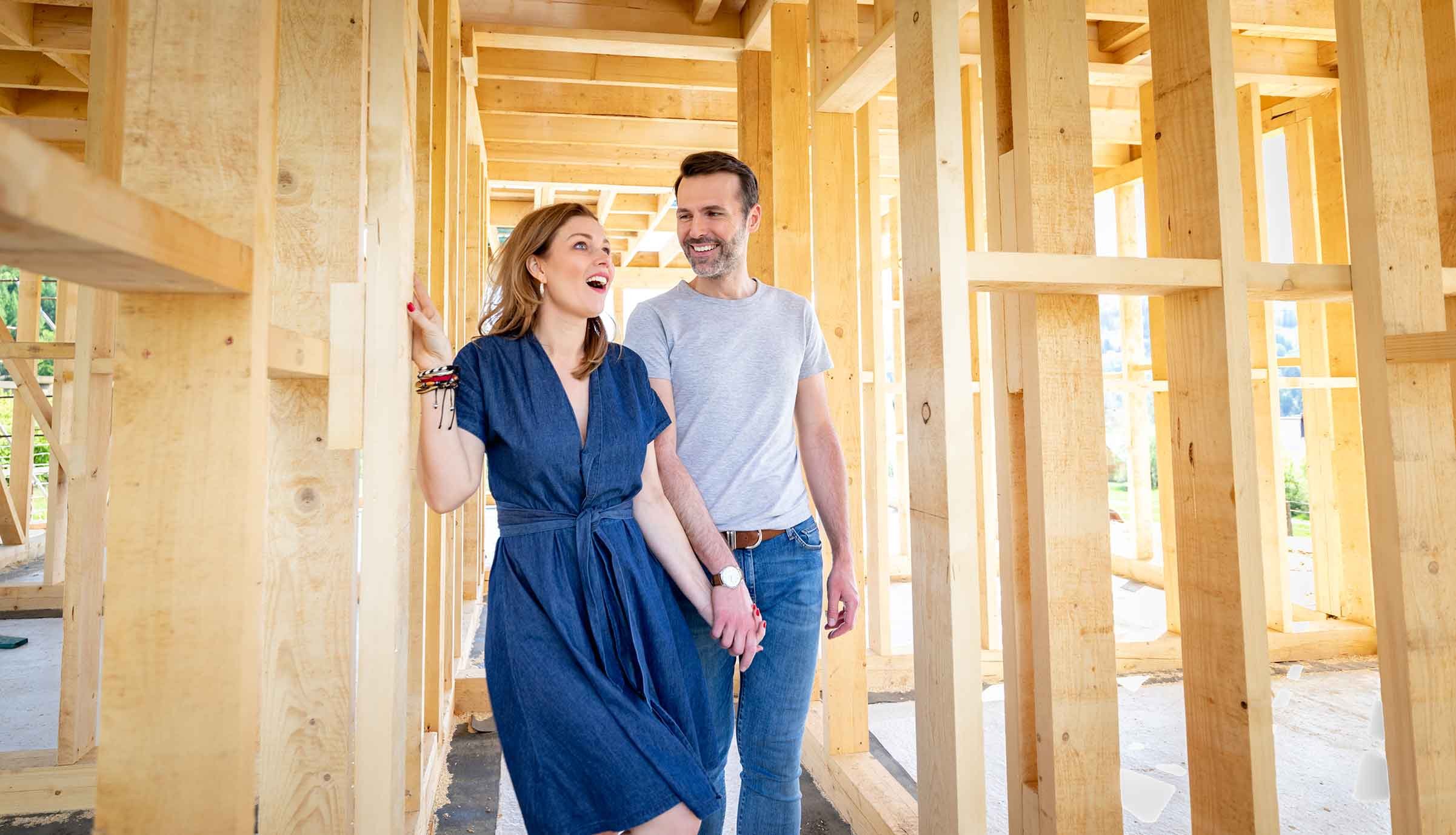 Smiling-couple-walking-through-a-home-under-construction-1