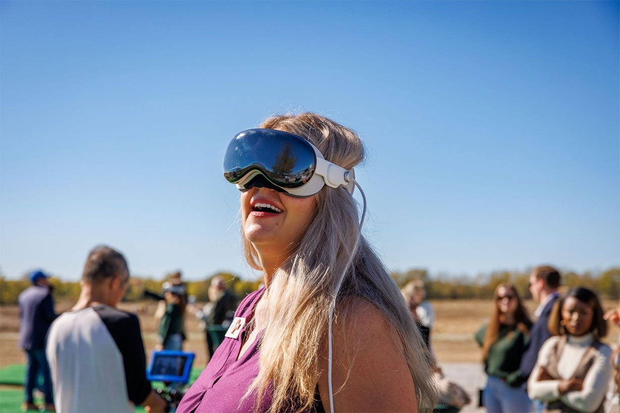 Smiling woman wearing Apple Vision Pro Headset at home builder event