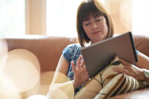 Mature woman browsing social media on a digital tablet