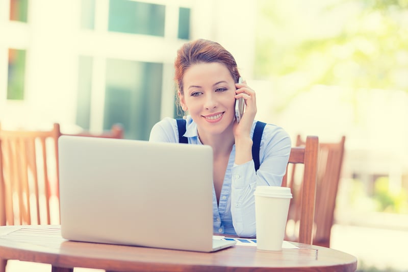 Portrait young happy woman talking on mobile phone working on computer laptop outside corporate office isolated city background college campus. Positive human face expression, emotion, success concept