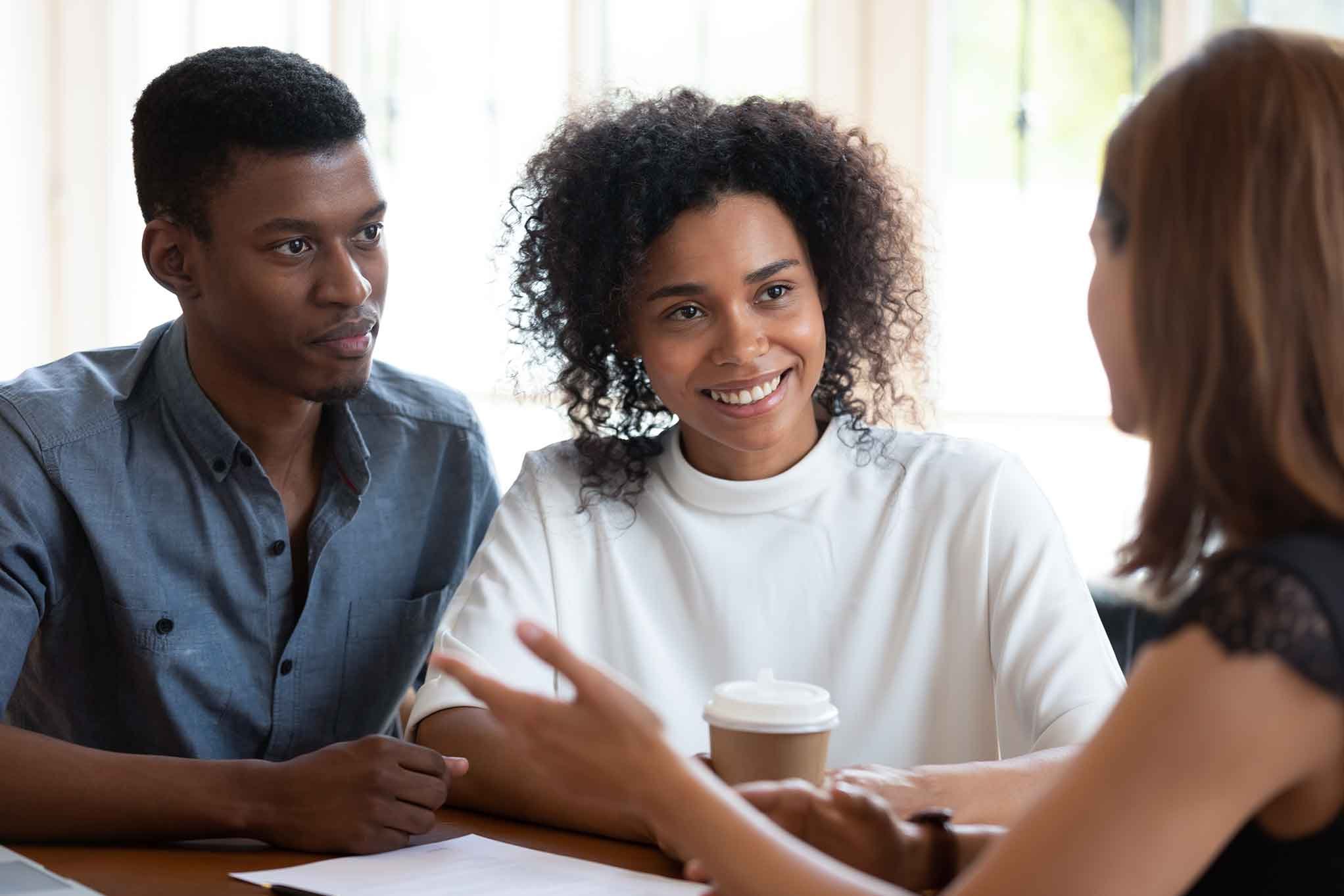 Young-black-couple-talking-to-new-home-sales-agent