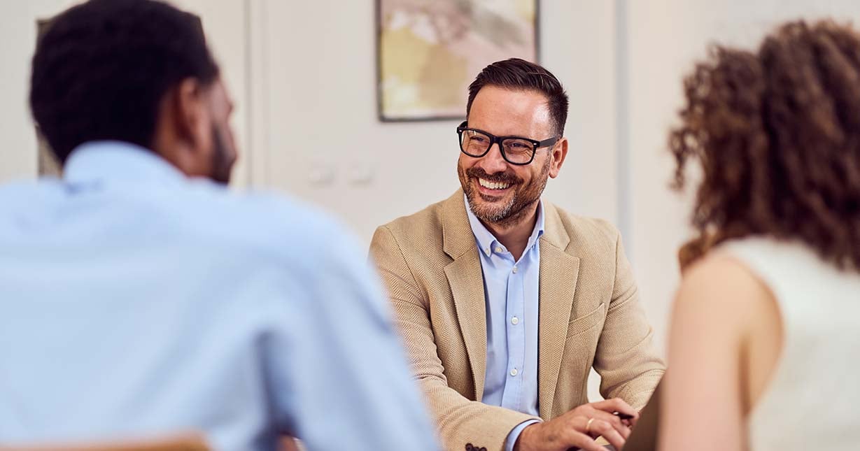 Young-couple-talking-to-a-new-home-sales-agent