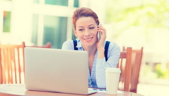 Young female working remotely on laptop outdoors