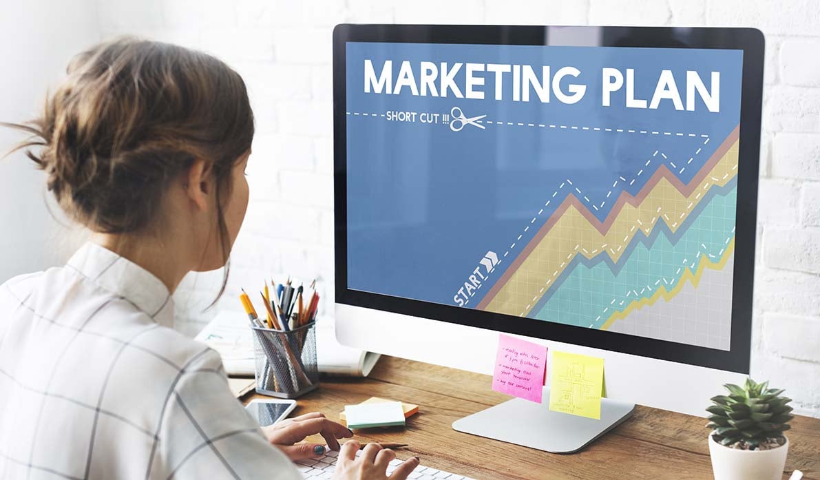 Young-woman-reasearching-a-home-builder-marketing-plan-on-a-desktop-computer