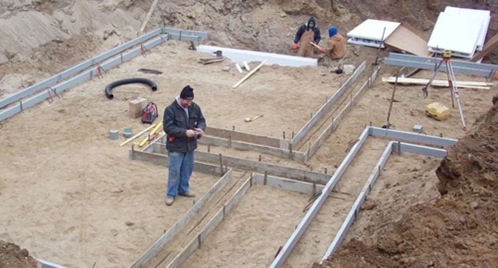 home builder working on job site communicating with builder via construction communication software