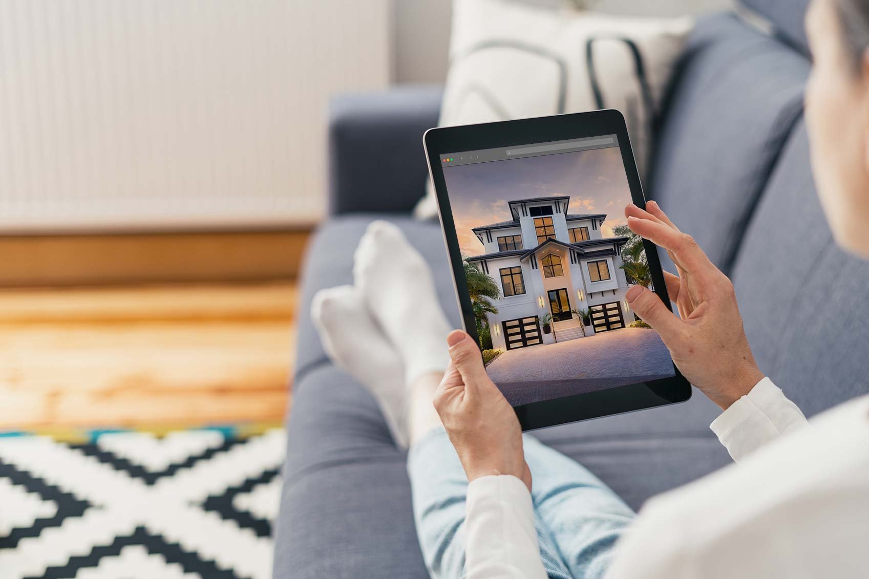 woman-on-ipad-looking-at-high-quality-photo-of-a-luxury-new-home