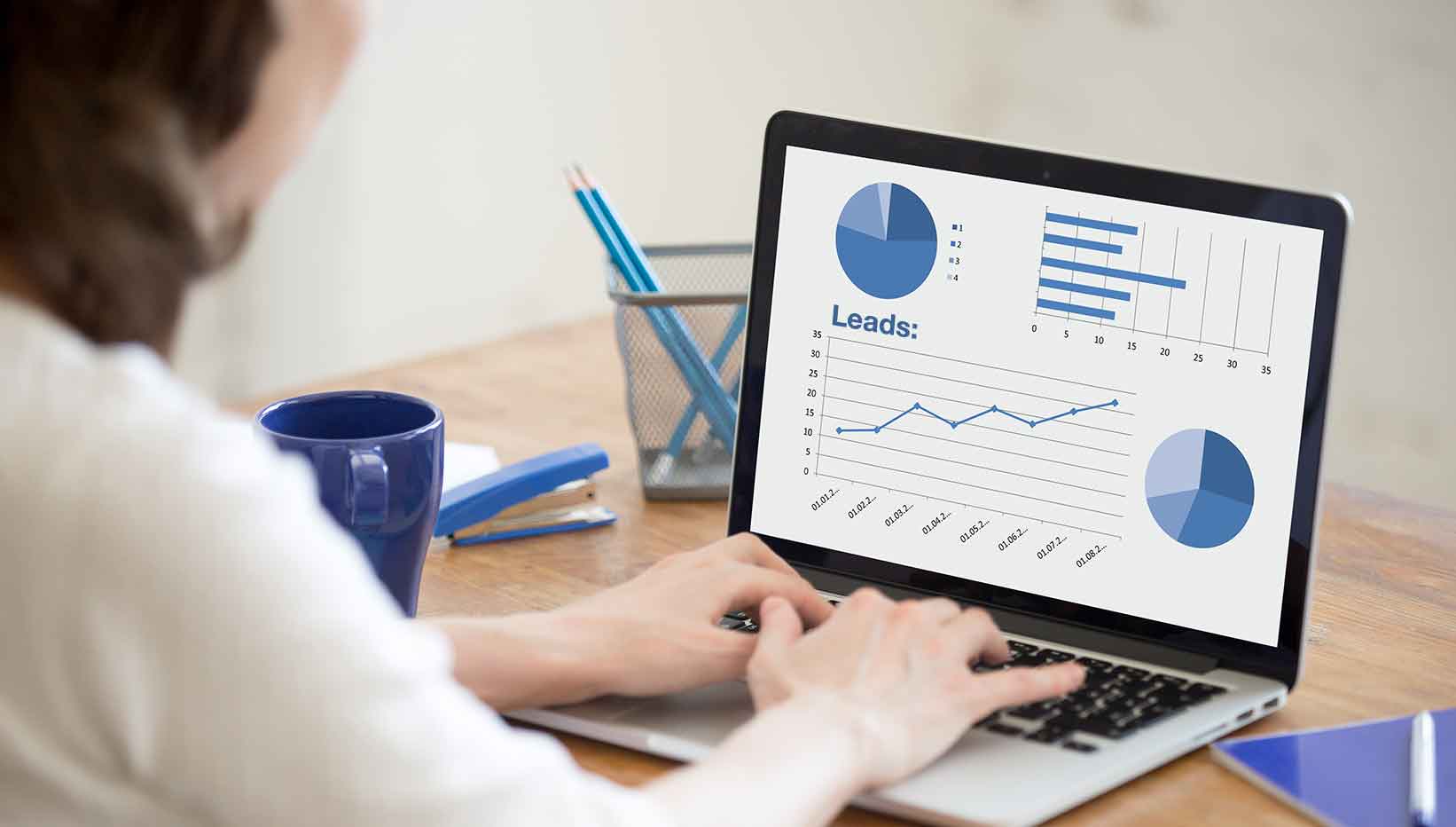 Builder-marketer-viewing-chart-of-increasing-leads-from-live-chat-on-laptop